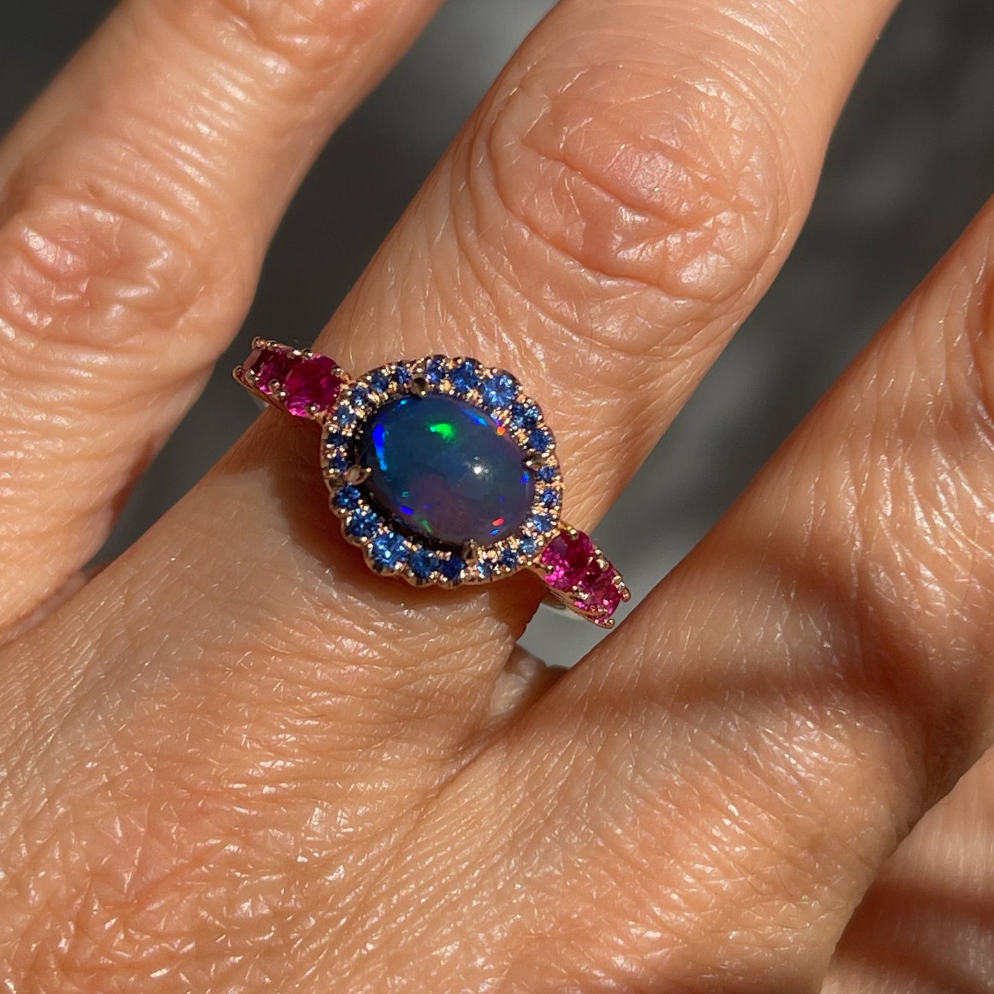 Sapphire and Opal Ring by NIXIN Jewelry modeled on hand. Natural Australian opal ring.