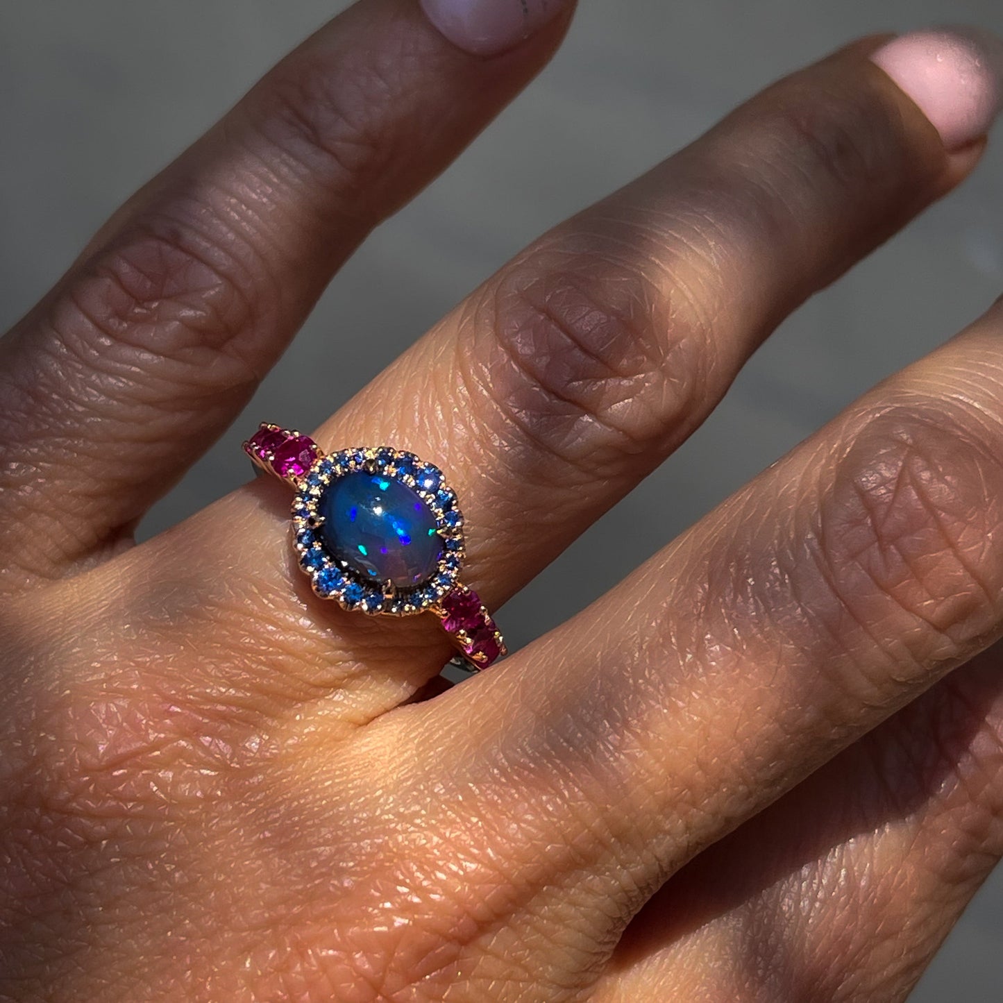 Sapphire and Opal Ring by NIXIN Jewelry modeled on hand. Sapphire and crystal opal ring.