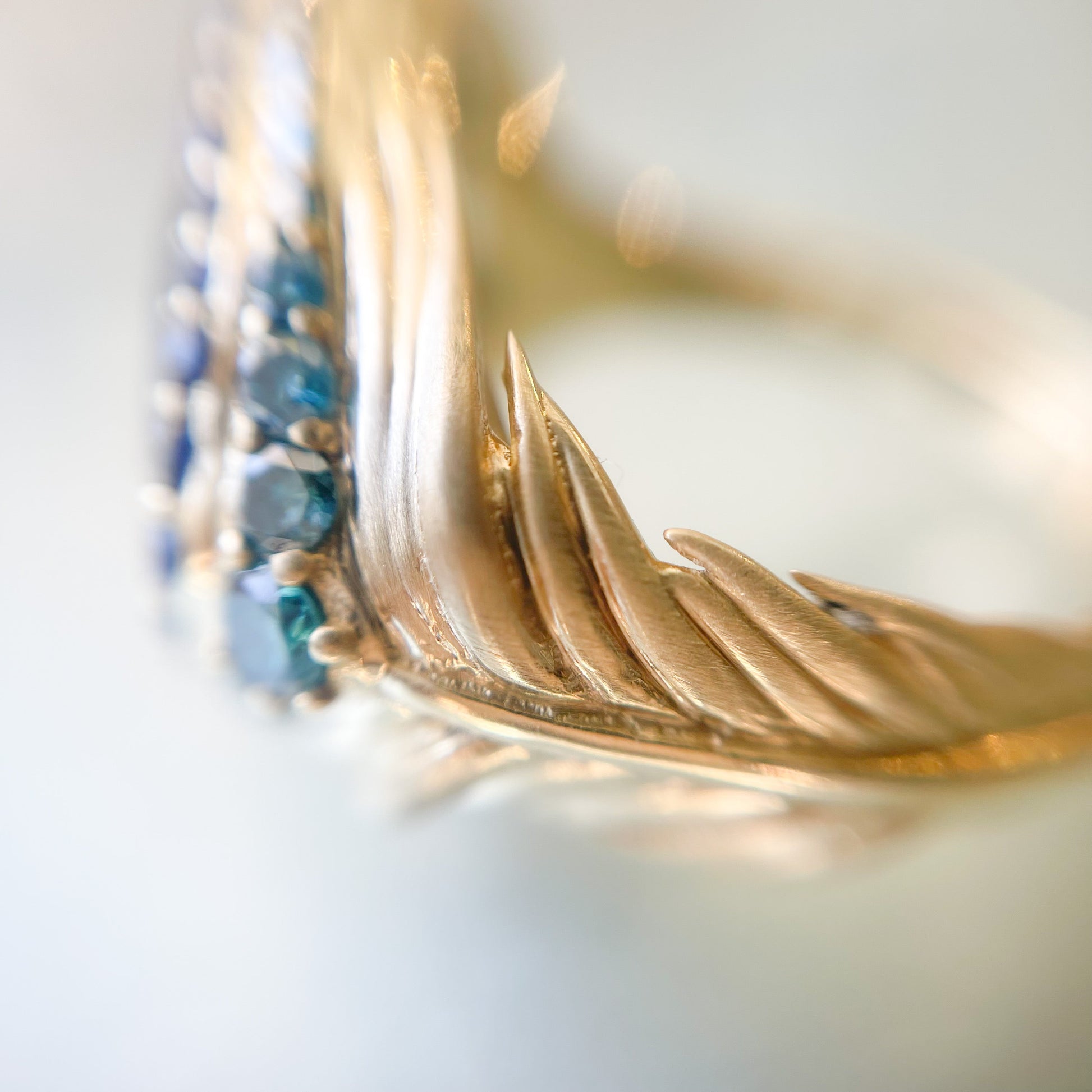 Australian Opal Ring by NIXIN Jewelry showing magnified detail of gold feather band. Opal Ring with peacock feather design.