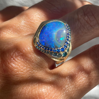 Australian Opal Ring by NIXIN Jewelry modeled on finger. Gold peacock ring with Australian Boulder Opal.