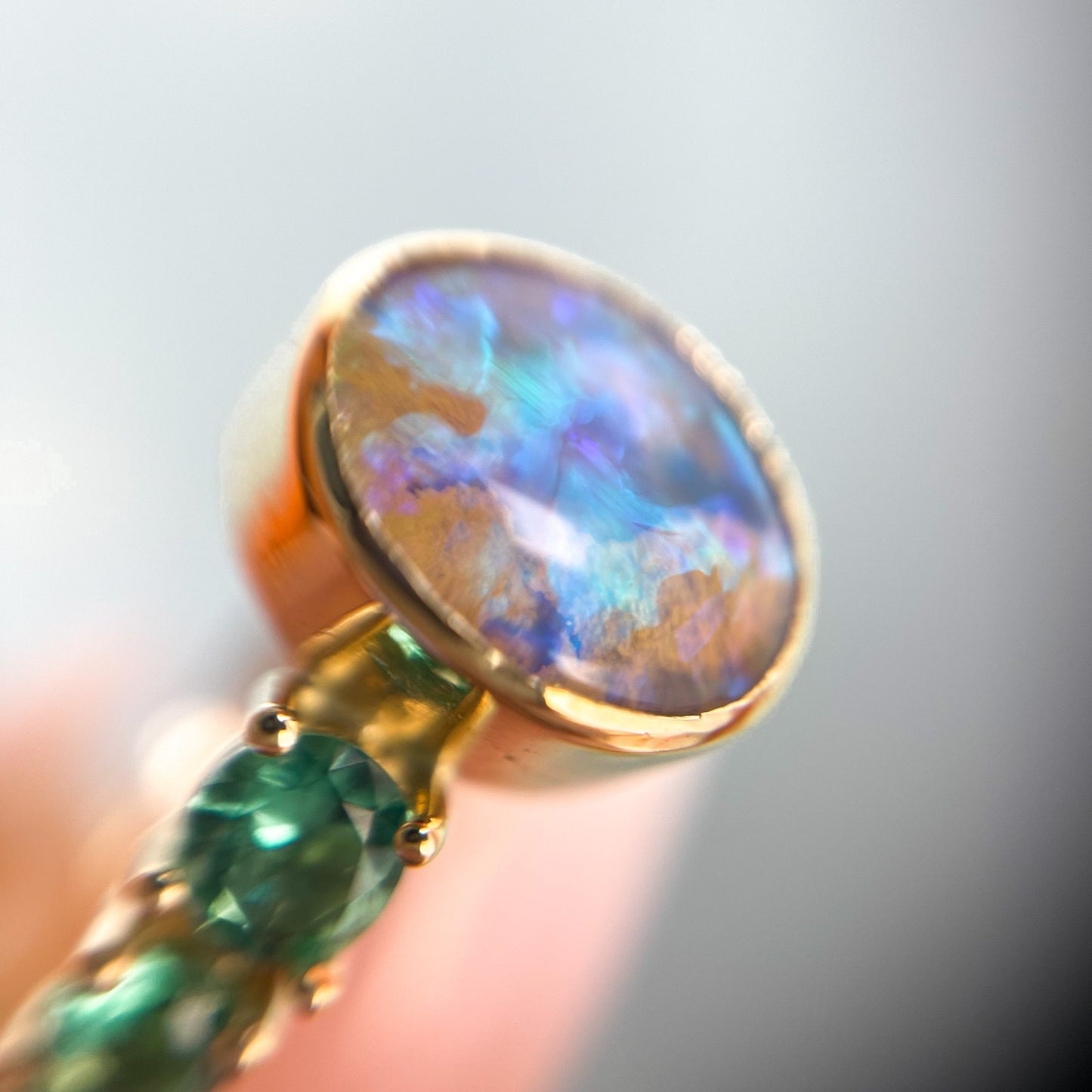Opal and emerald ring by NIXIN Jewelry shown close up