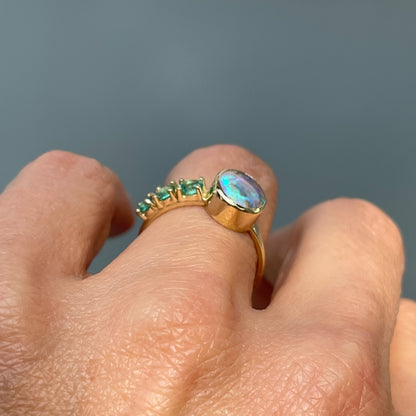Emerald and opal ring by NIXIN Jewelry shown in profile on hand