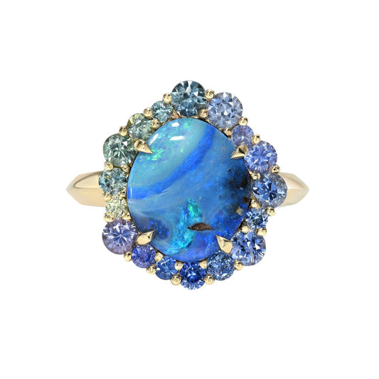 Australian Opal Ring by NIXIN Jewelry with a blue opal and sapphires. Shown against a white backdropl