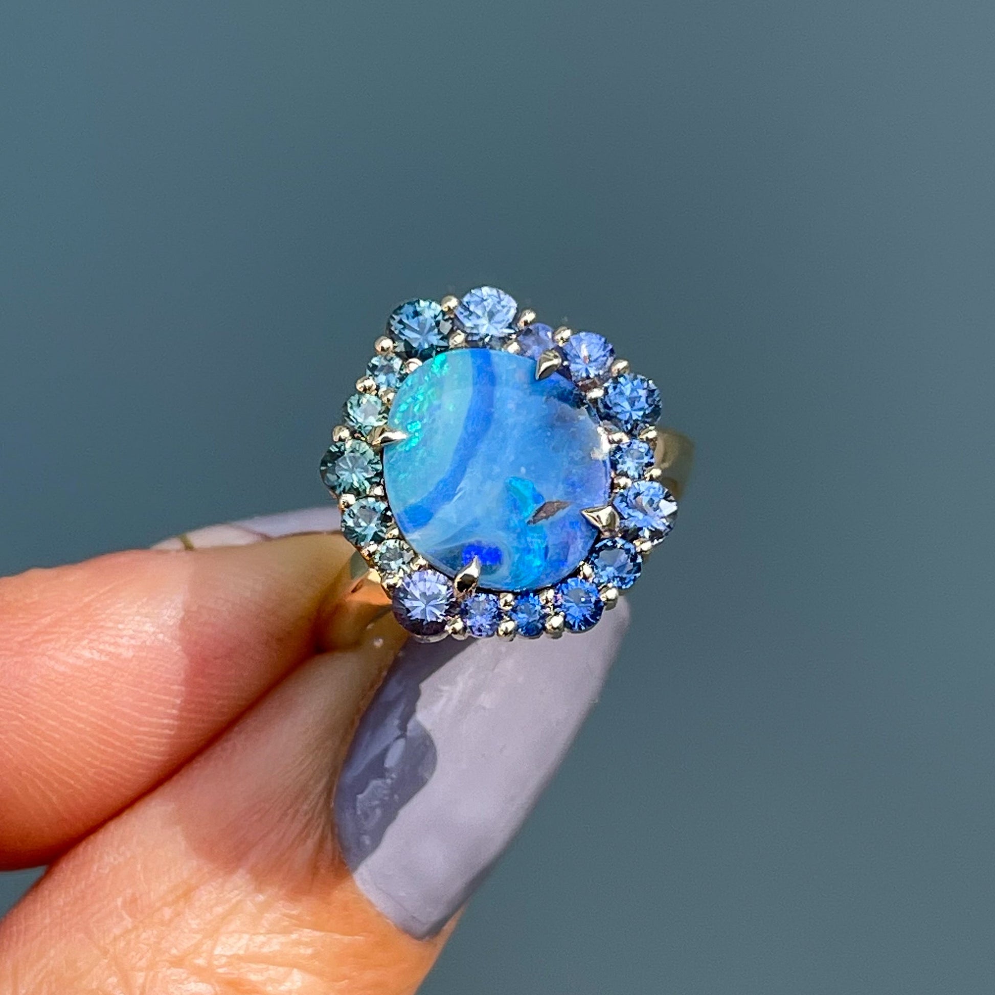 Australian Opal Ring by NIXIN Jewelry held in sunlight. One of a kind Australian blue opal ring.