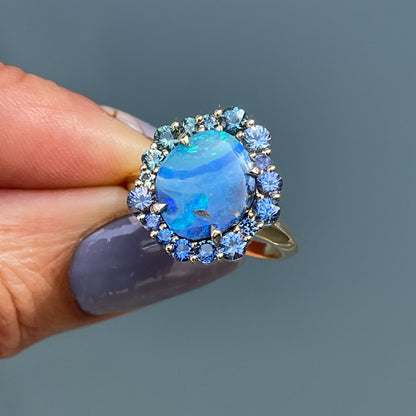 Australian Opal Ring by NIXIN Jewelry held in the sun. Boulder opal ring set in 14k yellow gold.