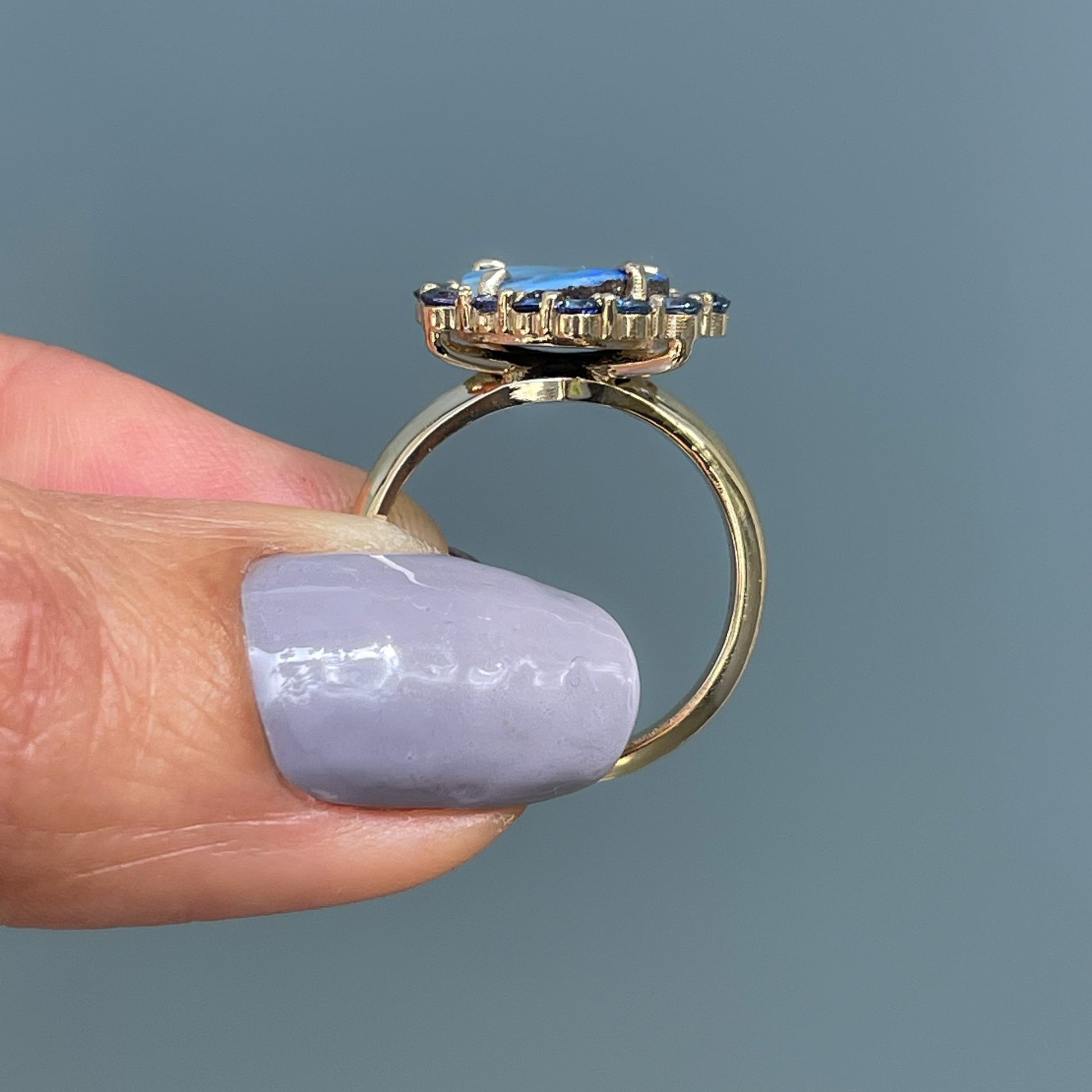 Australian Opal Ring by NIXIN Jewelry held showing ring in profile. 