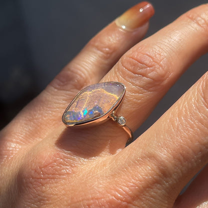 Zion Dali Australian Opal Ring by NIXIN Jewelry modeled on hand. Opal ring with diamonds.